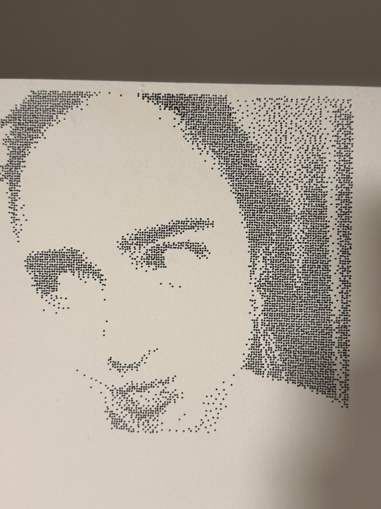 The finished pen drawing on paper, a portrait made of thousands of small black dots drawn by a Cricut Maker