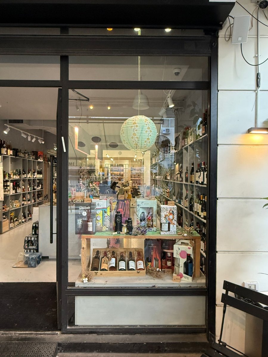 The liquor store window before, with a mixed display of gift boxes and bottles