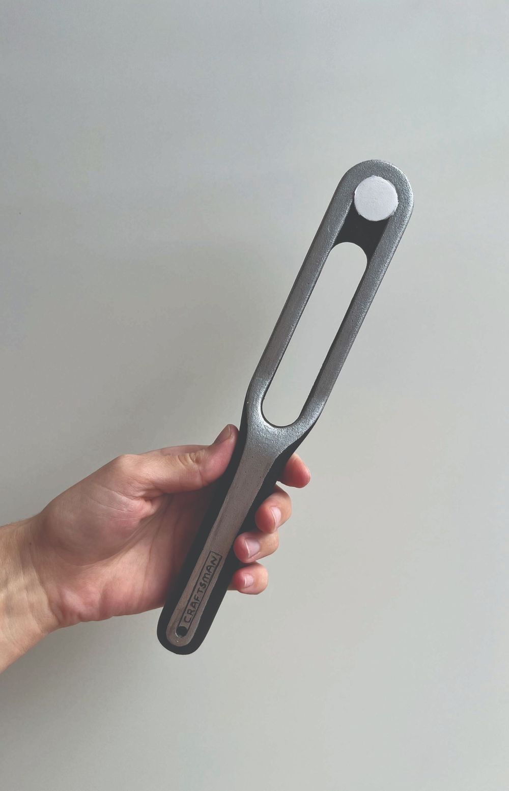 Open project: Water Pump Pulley Tool, a hand holding the slotted grey tool with its white socket end