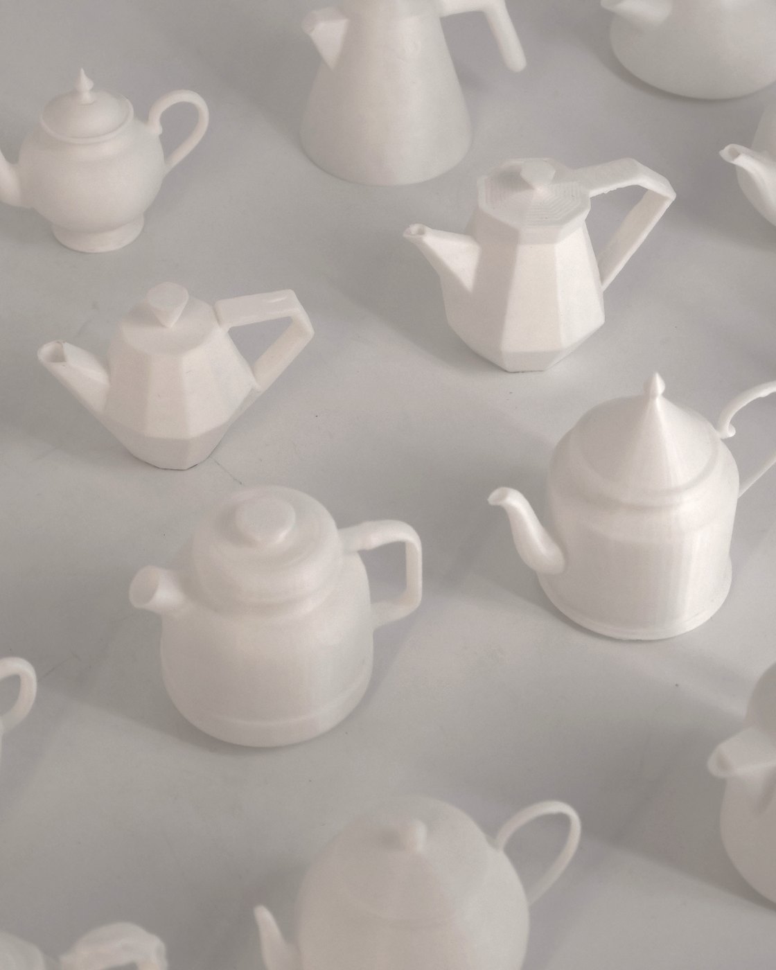 A field of small white 3D-printed teapots in many different forms, seen from above